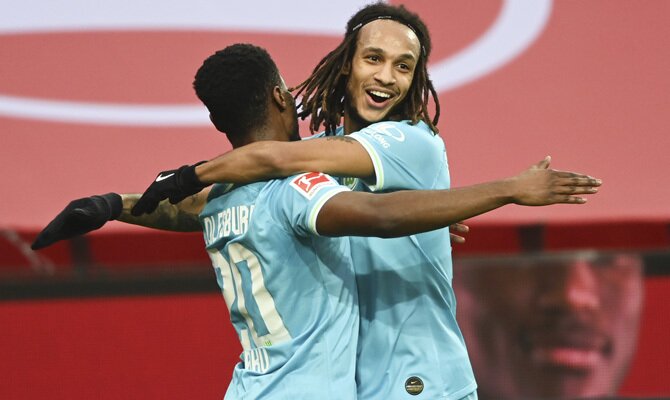 Baku y Mbabu celebrando un gol, lo que ayudaría a cumplir con los pronósticos en el Wolfsburgo vs Borussia Mönchengladbach