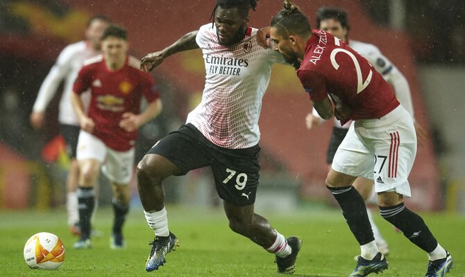 Kessie y Telles luchan por el balón. Revisa las mejores cuotas para el Milan vs Manchester United