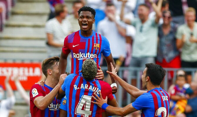 Ansu Fati es levantado por sus compañeros. Picks y cuotas Atlético de Madrid vs Barcelona, LaLiga.