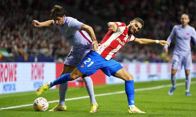 Carrasco y Sergi Roberto luchan por la posesión del balón. Cuotas Barcelona vs Atlético de Madrid.