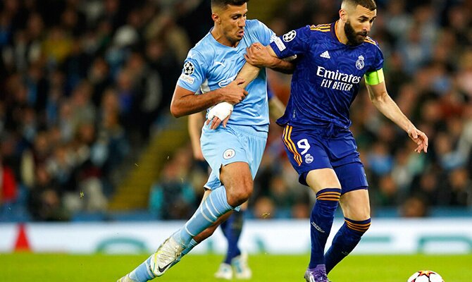 Rodri del Manchester City y Benzema del Real Madrid disputando un balon