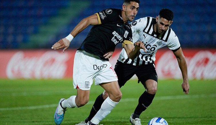 Pablo Sabbag de Alianza Lima con el balón ante Alfio Oviedo de Libertad