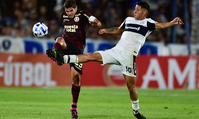 Aldo Corzo de Universitario y Tomas Muro de Gimnasia pelean por el balón