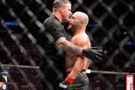 Alexander Volkanovski es sostenido por el réferi tras una pelea de UFC