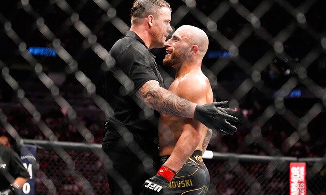 Alexander Volkanovski es sostenido por el réferi tras una pelea de UFC