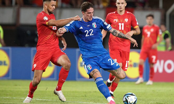 Nicolo Zaniolo de Italia protege la pelota con la marca de Ezgjan Alioski de Macedonia